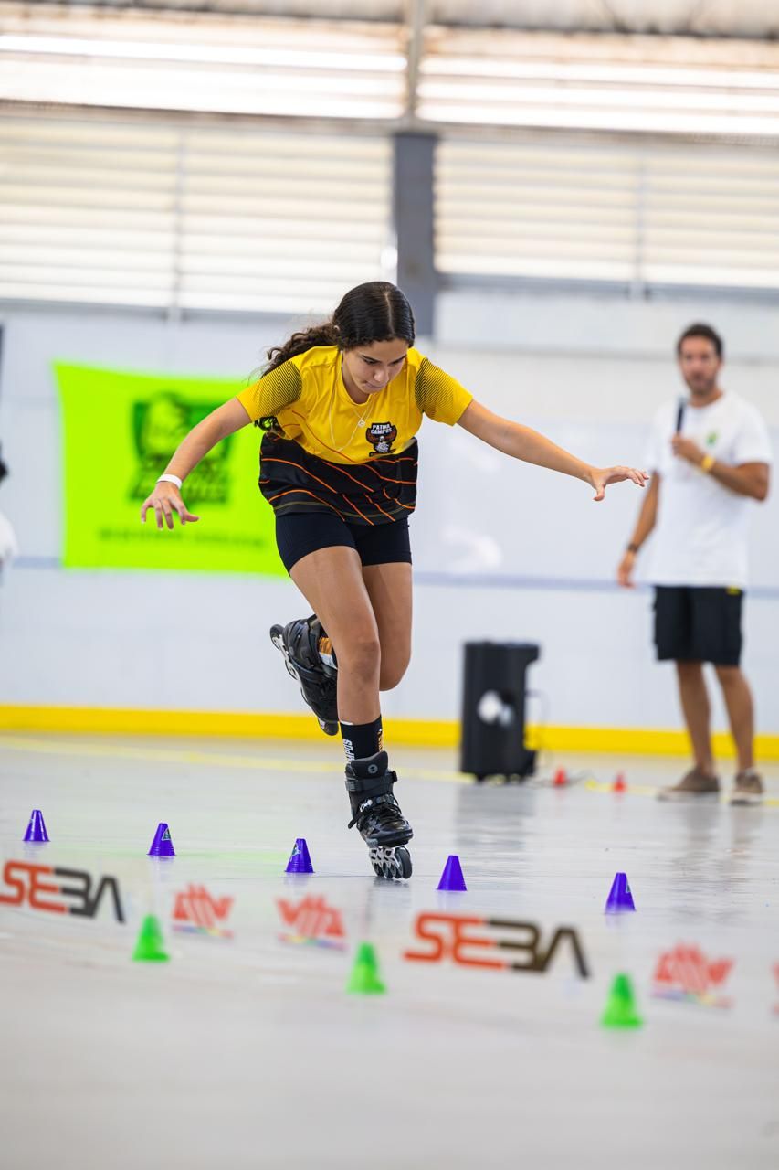 Yasmin em equilíbrio sobre um patim, desviando dos cones